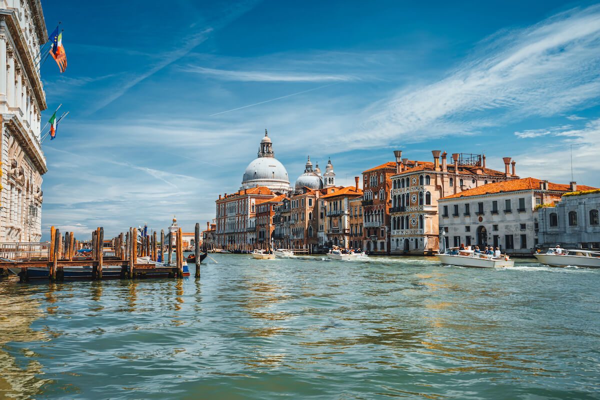 A small tour group in a famous place (Europe, a national park), or Venice's Grand Canal. Landscape.